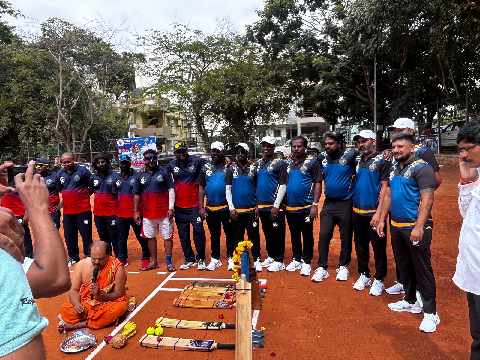 Team photo with the priest performing the inaugural pooja at the Kempapura Premier League